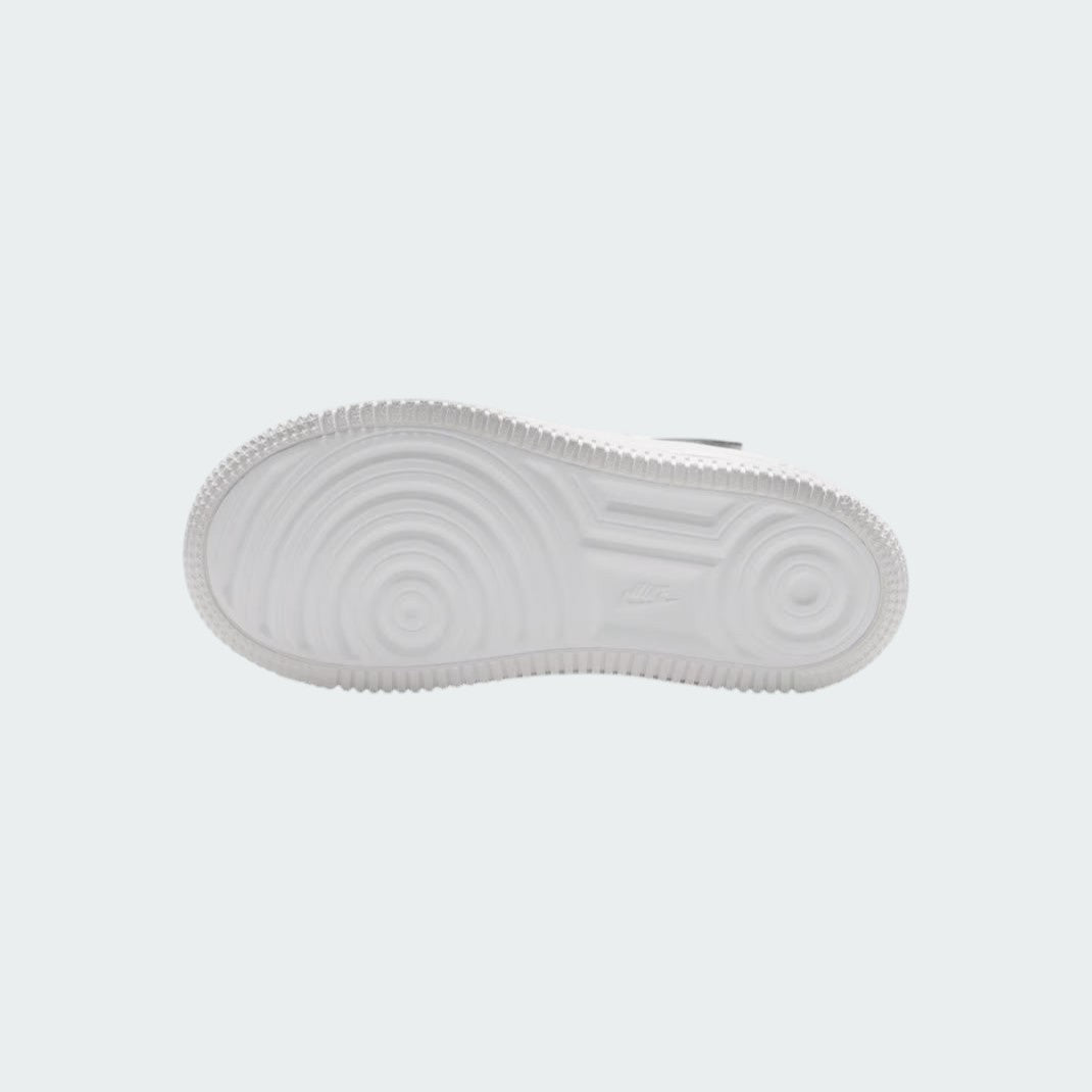 View of the outsole of the Nike Air Force 1 Low EasyOn Kids' white trainers, showing the durable rubber sole with pivot circles for traction.
