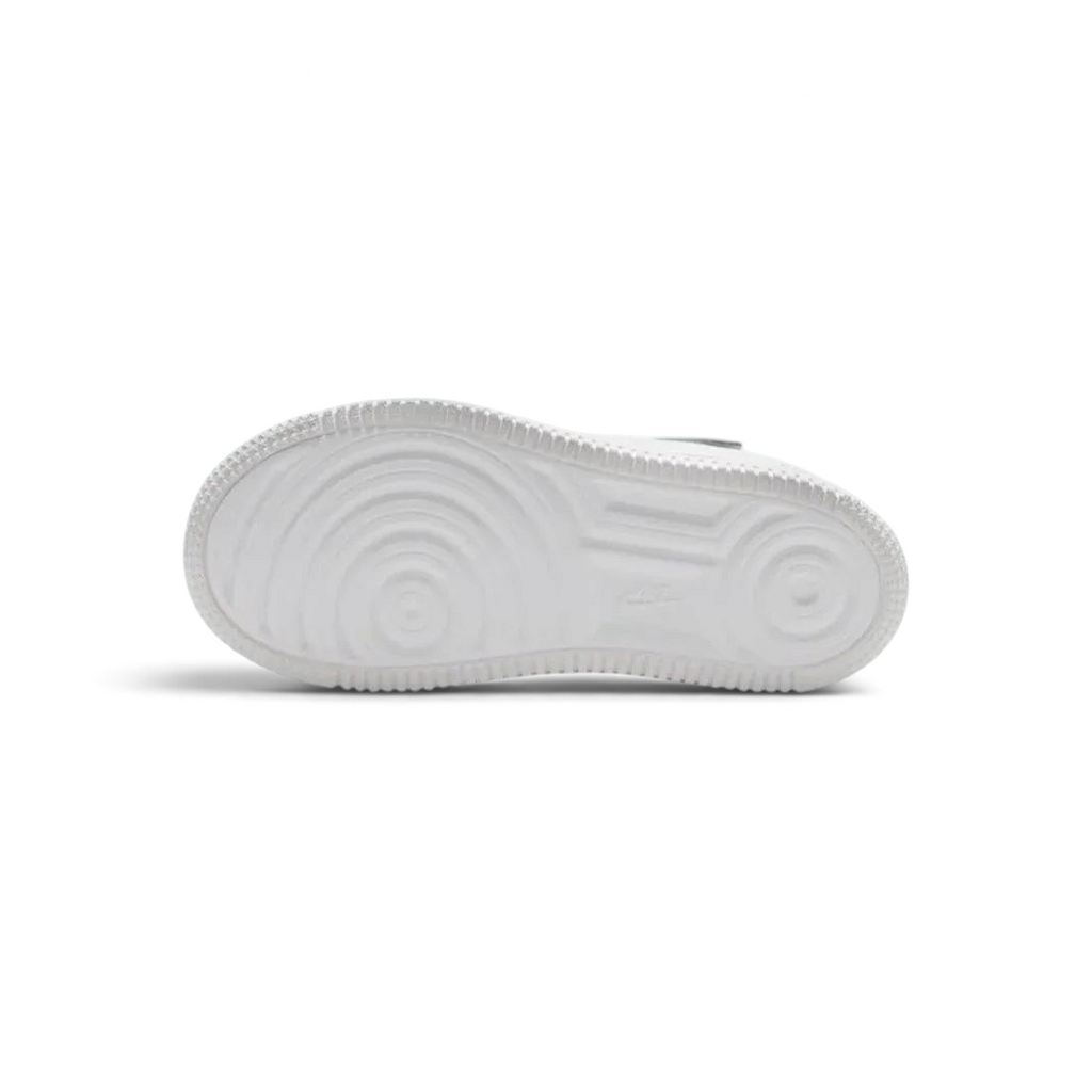 View of the outsole of the Nike Air Force 1 Low EasyOn Kids' white trainers, showing the durable rubber sole with pivot circles for traction.