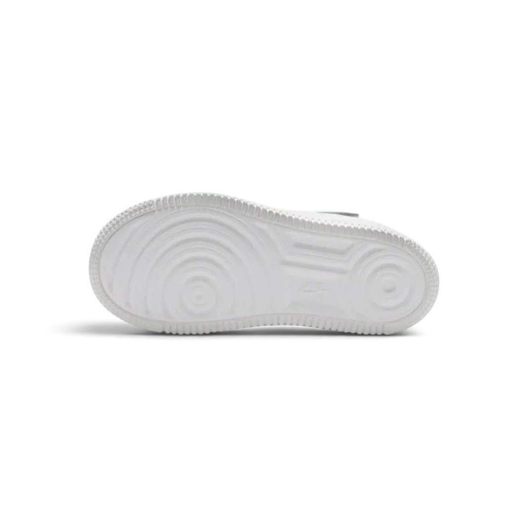View of the outsole of the Nike Air Force 1 Low EasyOn Kids' white trainers, showing the durable rubber sole with pivot circles for traction.