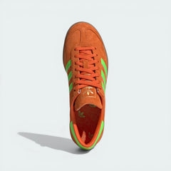 Top-down view of the trainers, showcasing the vibrant orange leather texture and the matching lace closure.