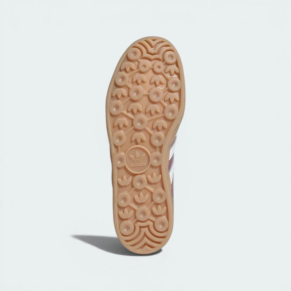 View of the classic gum rubber outsole, detailing the textured hexagonal traction pattern.