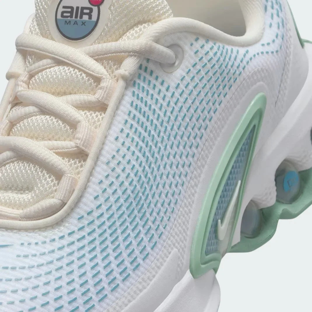 Close-up zoom on the front of the Nike Air Max DN Juniors' trainers, showing the mesh upper texture, haptic print details, and lacing system.