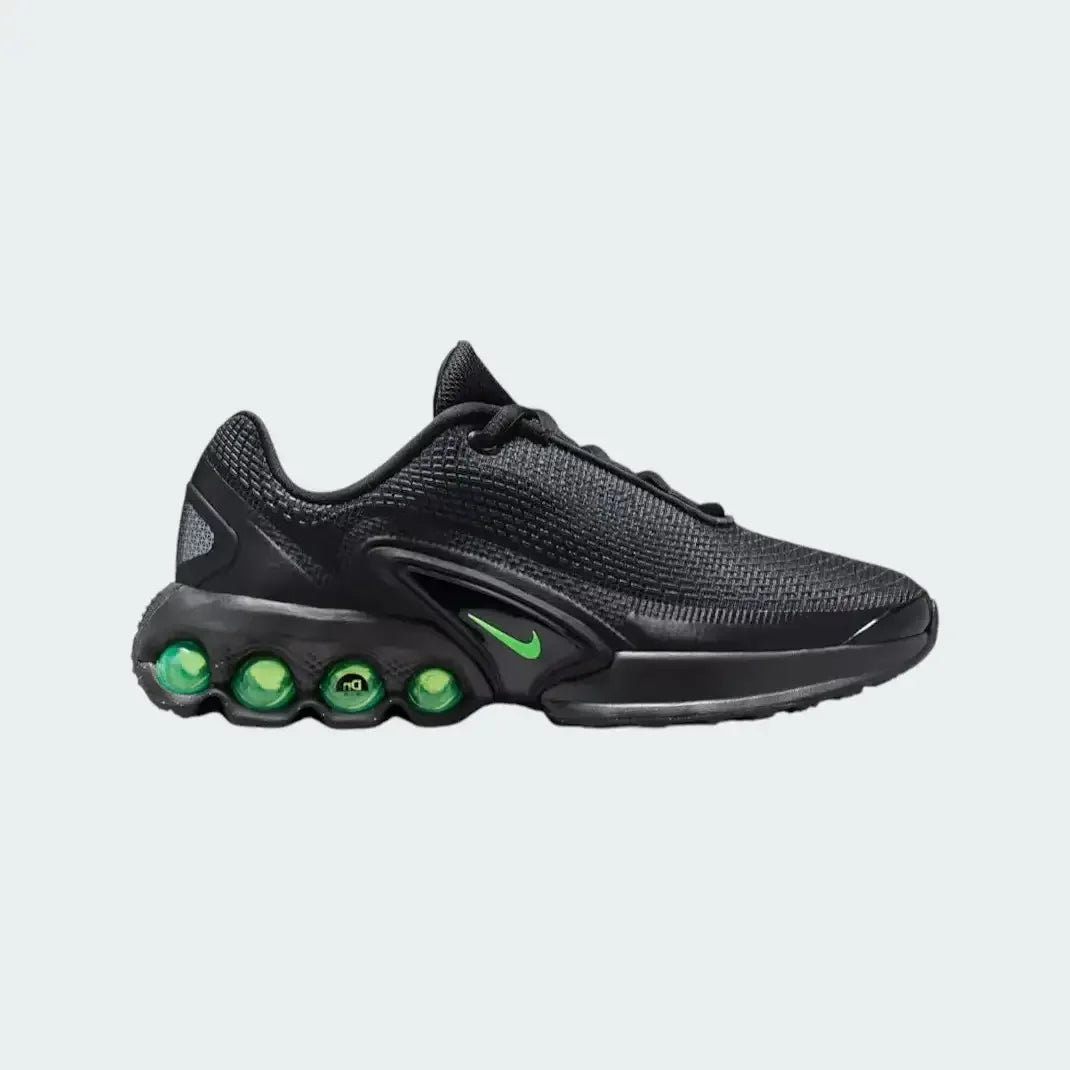Nike Air Max DN Juniors' running trainers in black with green strike accents, side profile showing visible Dynamic Air unit in the heel, textured upper, and sleek silhouette Main image