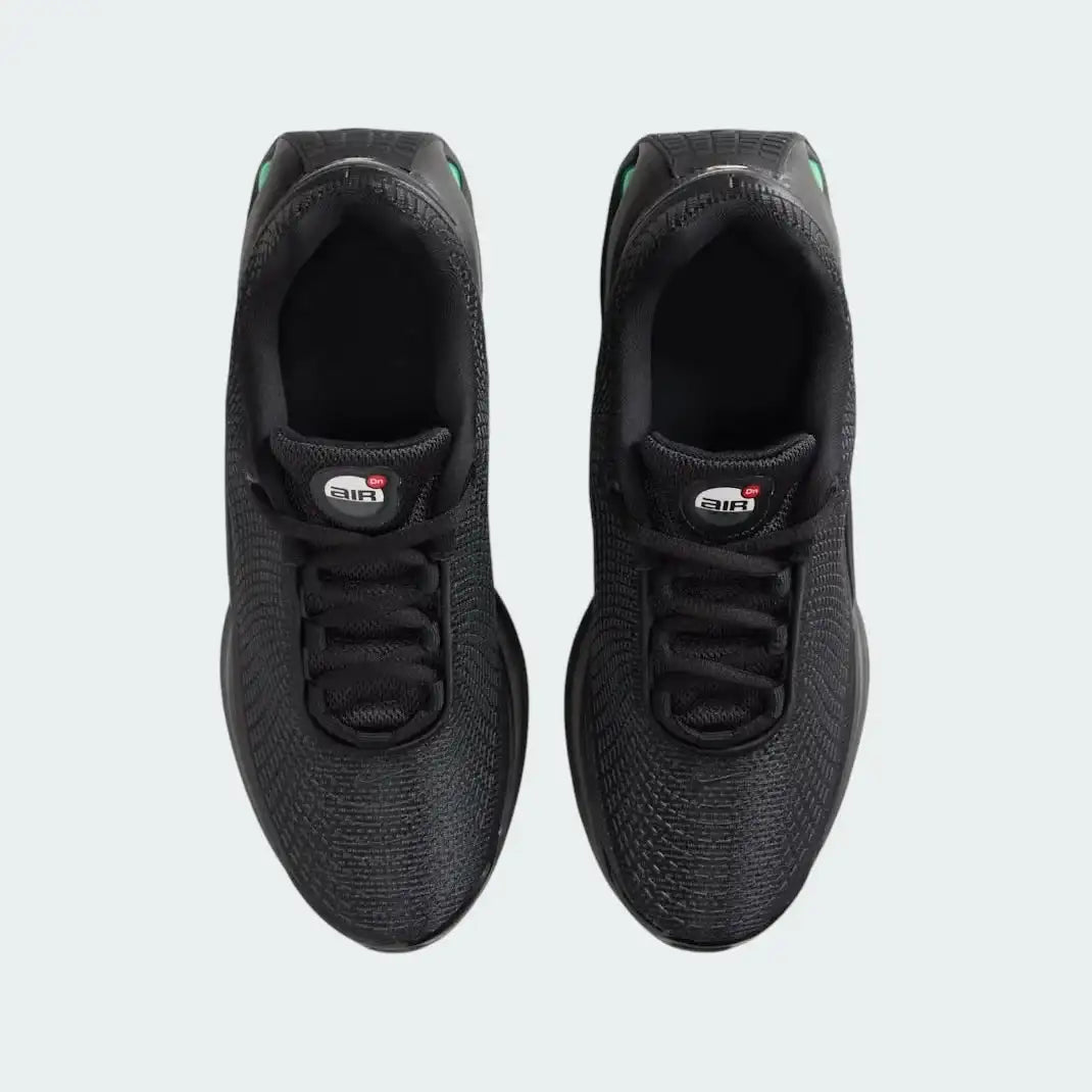Top-down view of a pair of Nike Air Max DN Juniors' running trainers in black, highlighting their futuristic design and lace-up closure.