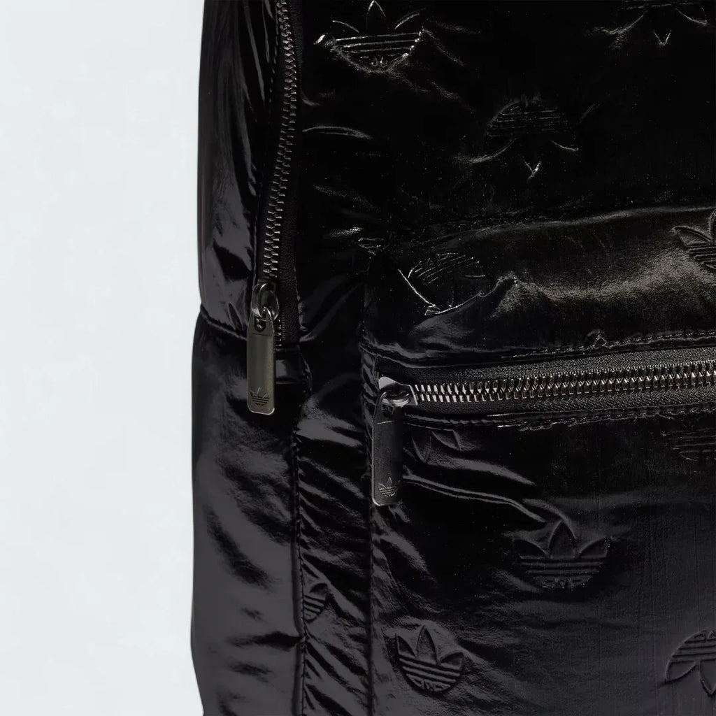 Close-up zoom on the fabric of the Adidas Puffy Satin Backpack in black, showing the smooth, slightly glossy satin texture and quilted effect.