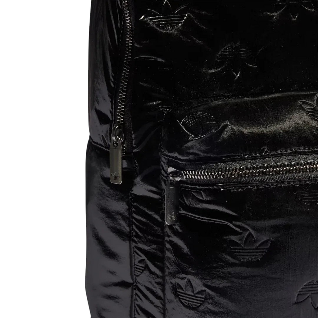 Close-up zoom on the fabric of the Adidas Puffy Satin Backpack in black, showing the smooth, slightly glossy satin texture and quilted effect.