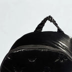 Adidas Puffy Satin Backpack in black zoomed in showing the zip and carry handle