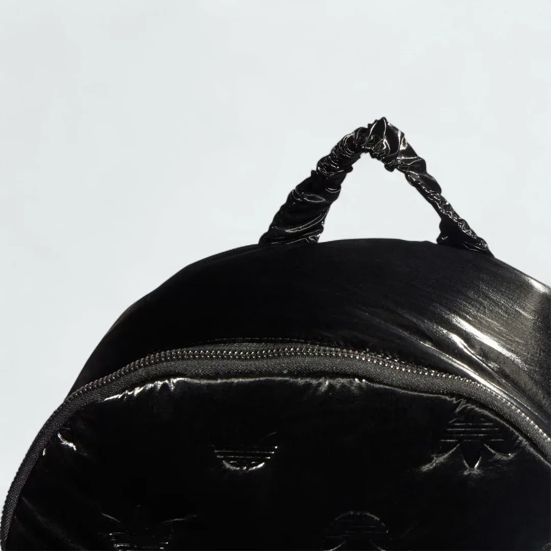 Adidas Puffy Satin Backpack in black zoomed in showing the zip and carry handle