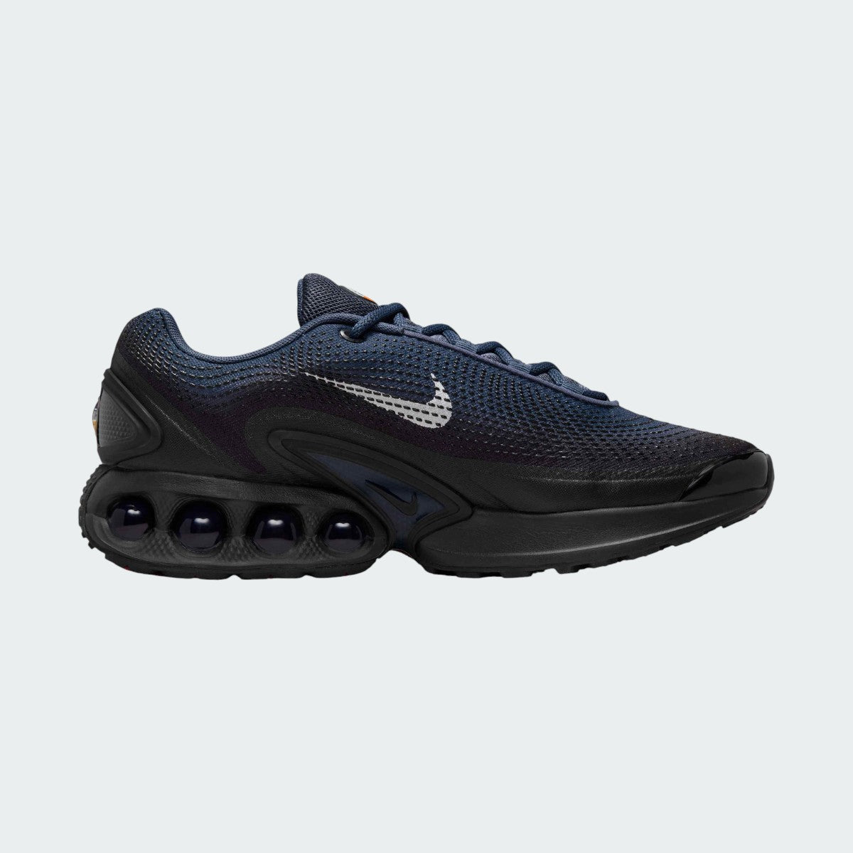 Nike Air Max DN Men's running shoes in dark navy with white accents, side profile showing visible Dynamic Air unit in the heel, textured upper, and sleek silhouette.