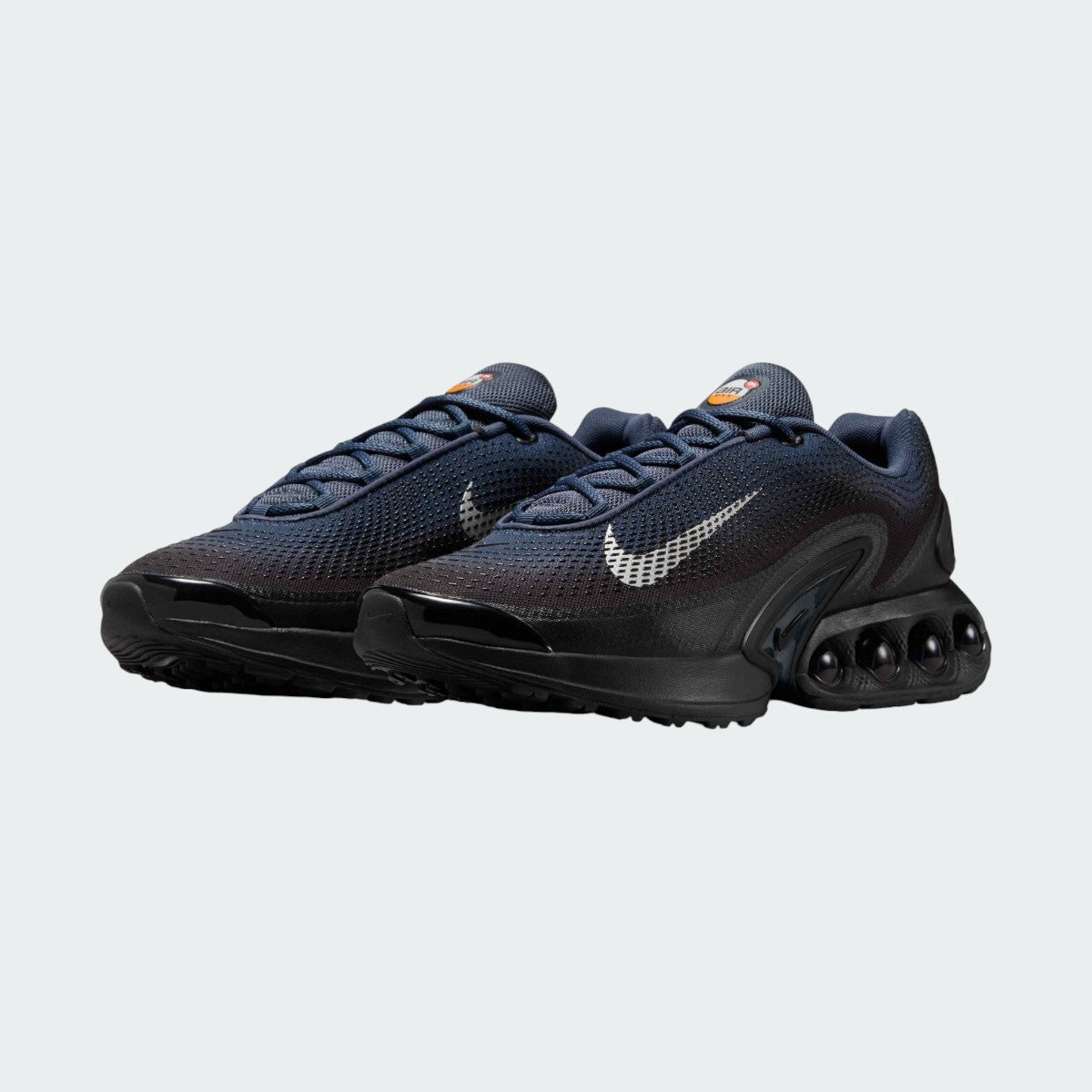 Angled view of two Nike Air Max DN Men's dark navy running shoes, side by side, showcasing their bold, modern design and prominent Air unit.