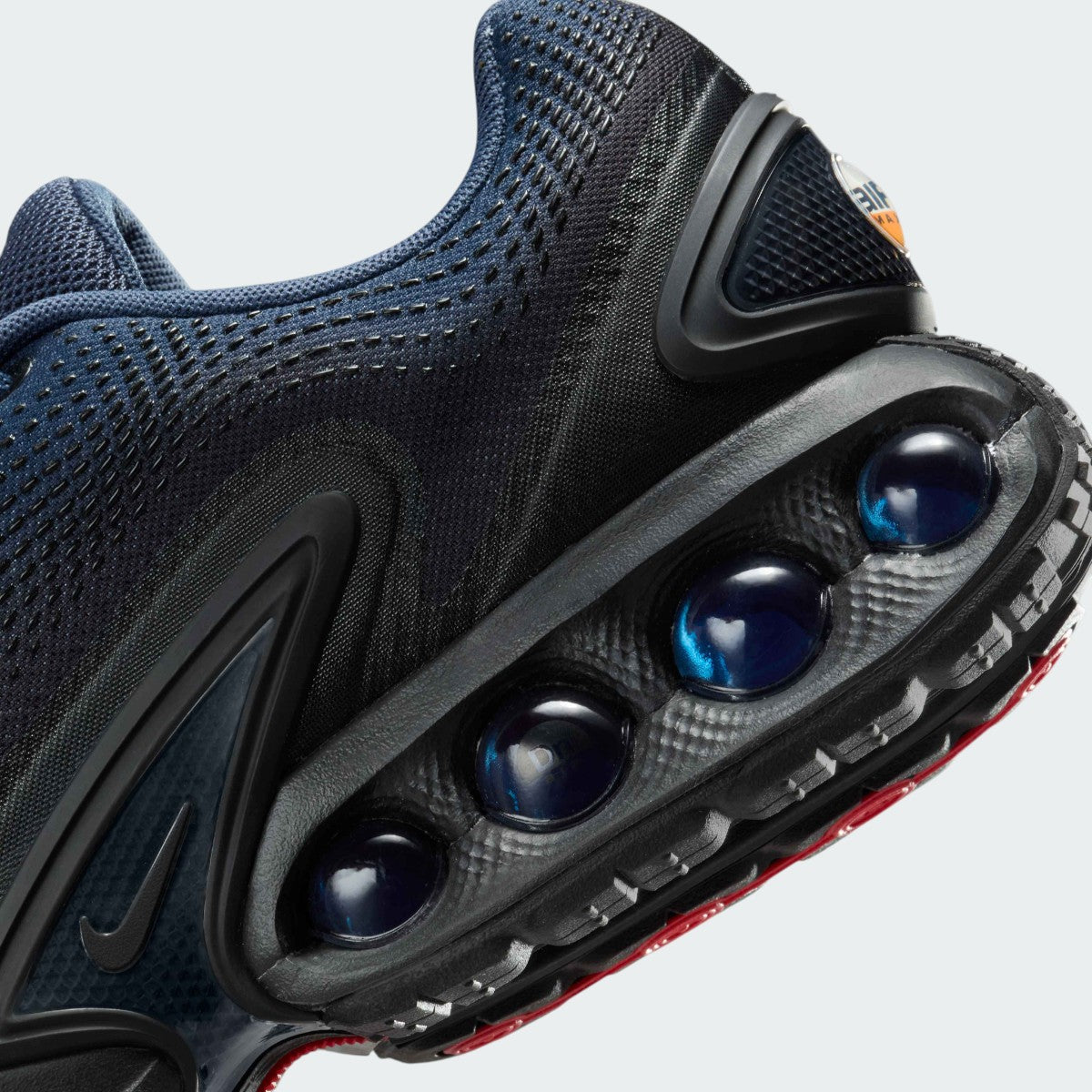Detailed zoom on the outsole and midsole of the Nike Air Max DN Men's dark navy running shoes, highlighting the dual-pressure Dynamic Air cushioning system and robust rubber outsole.