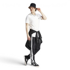 Adidas Adibreak Button Track Pants in black with a subtle animal print, front view showing the elastic drawcord waist and the full line of snap buttons down the side.