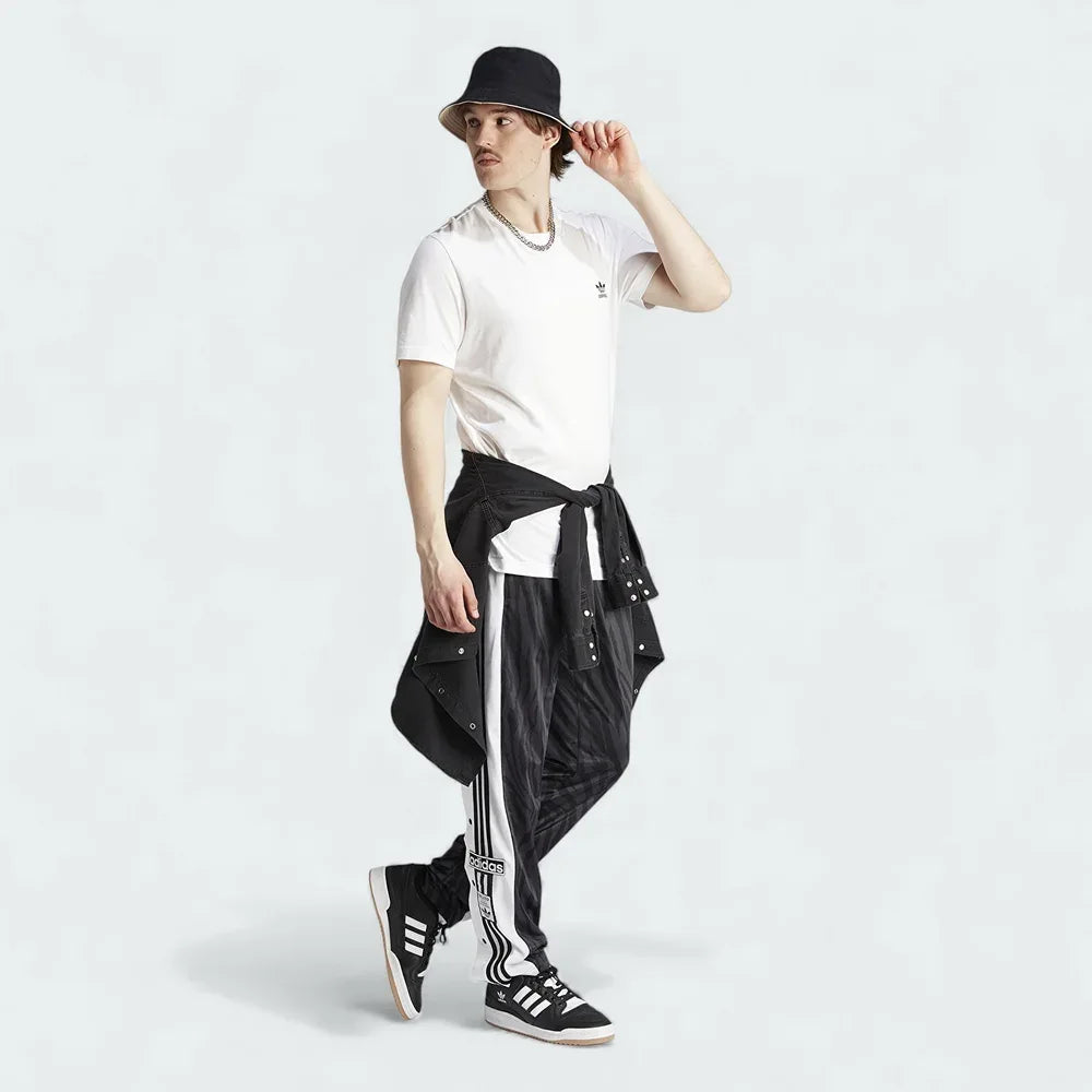 Adidas Adibreak Button Track Pants in black with a subtle animal print, front view showing the elastic drawcord waist and the full line of snap buttons down the side. Main image
