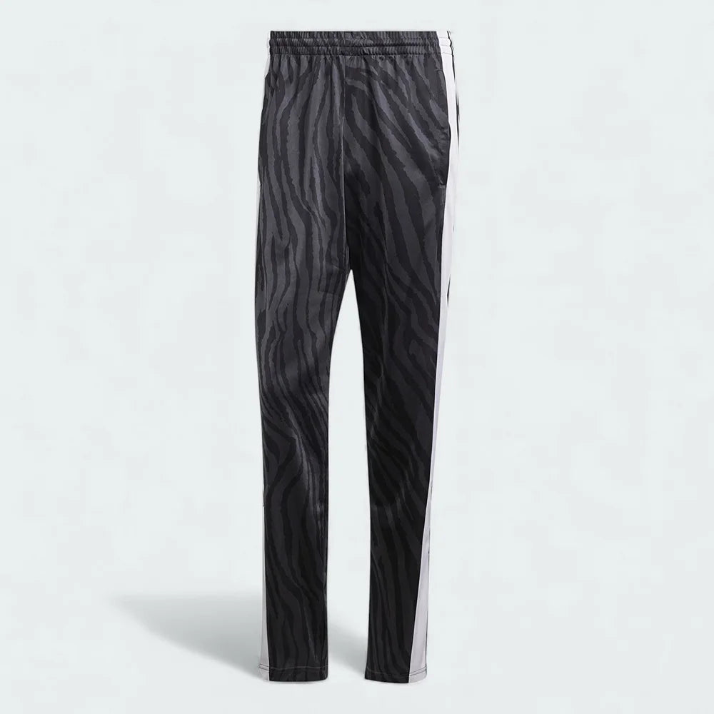 Adidas Adibreak Button Track Pants in black with a subtle animal print, front view showing the elastic drawcord waist and the full line of snap buttons down the side.