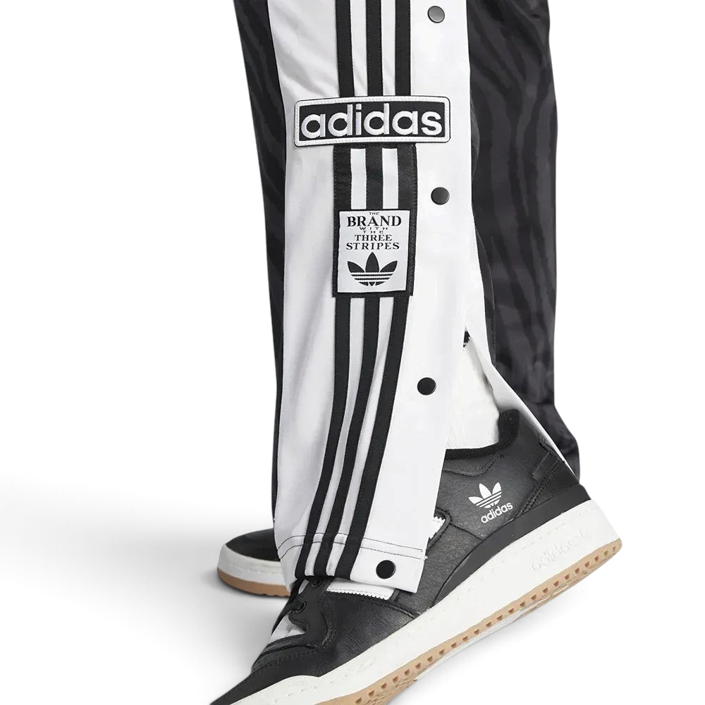 Adidas Adibreak Button Track Pants in black with some side snaps undone, showing the exposed contrasting material underneath and the "breakaway" style.