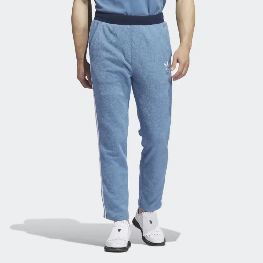 Adidas x Bogey Boys Golf Men's Track Pants in blue, front view showing the elastic drawcord waist, side pockets, and Trefoil/Bogey Boys logo on the hip. Main image