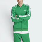 Highlights the high-velocity sweep of the continuous white 3-Stripes running flawlessly down the professional, deep emerald depth of the Green sleeve panels.