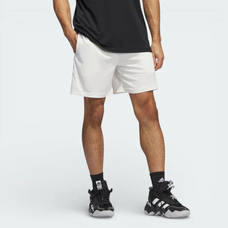 White adidas Badge of Sport Basketball shorts worn by a model looking from the front Main image