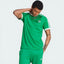Model profile of the green Adicolor Sport t-shirt, showcasing the iconic white 3-Stripes running from the shoulder to the sleeve hem.