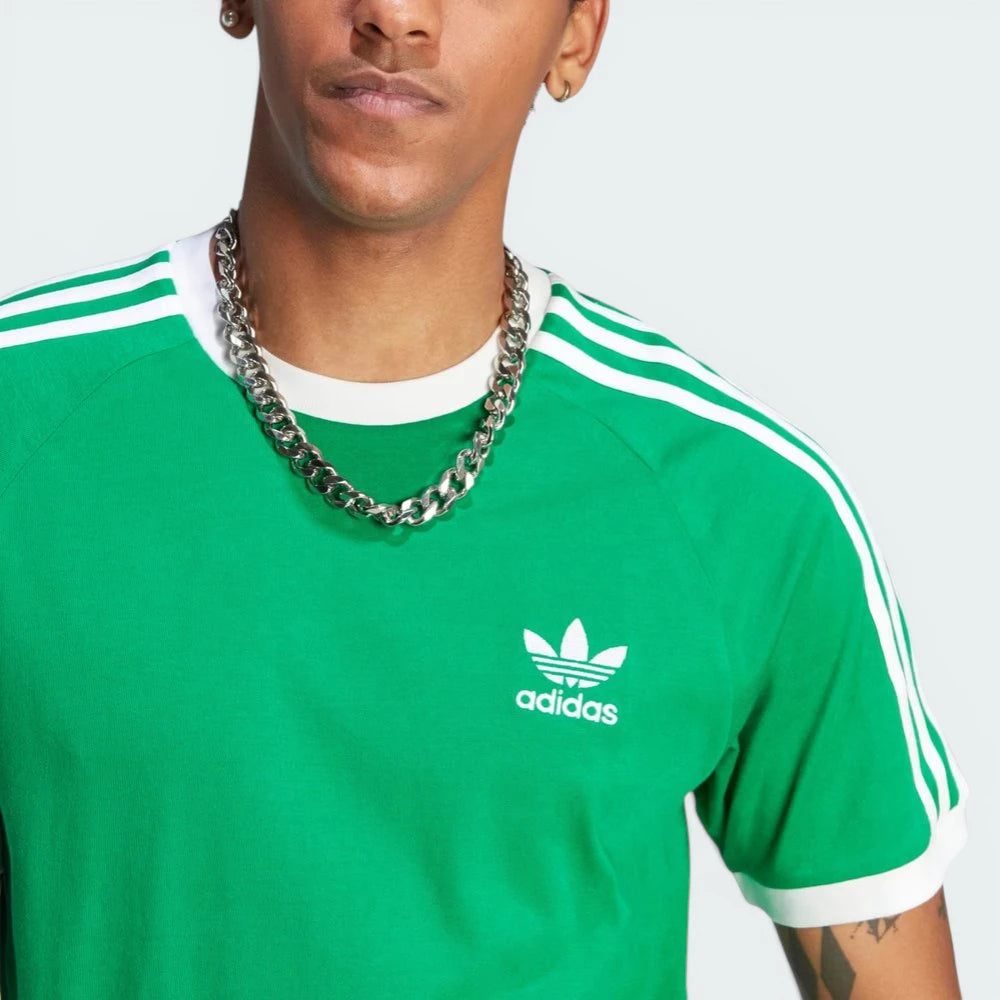 Close-up of the embroidered Trefoil on the chest, highlighting the precision of the white stitching against the green fabric.