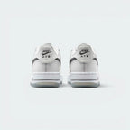 Focuses on the contoured shape of the low-cut collar, highlighting the clean embroidered Nike Air block text stitched squarely into the reflective rear heel tab.