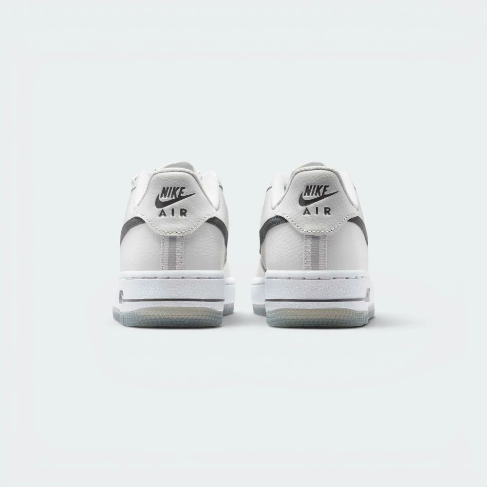 Focuses on the contoured shape of the low-cut collar, highlighting the clean embroidered Nike Air block text stitched squarely into the reflective rear heel tab.