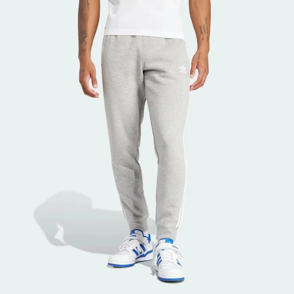 Front profile of the Adicolor 3-Stripes joggers, showing the slim-fit silhouette and the iconic contrast stripes running down  Main image