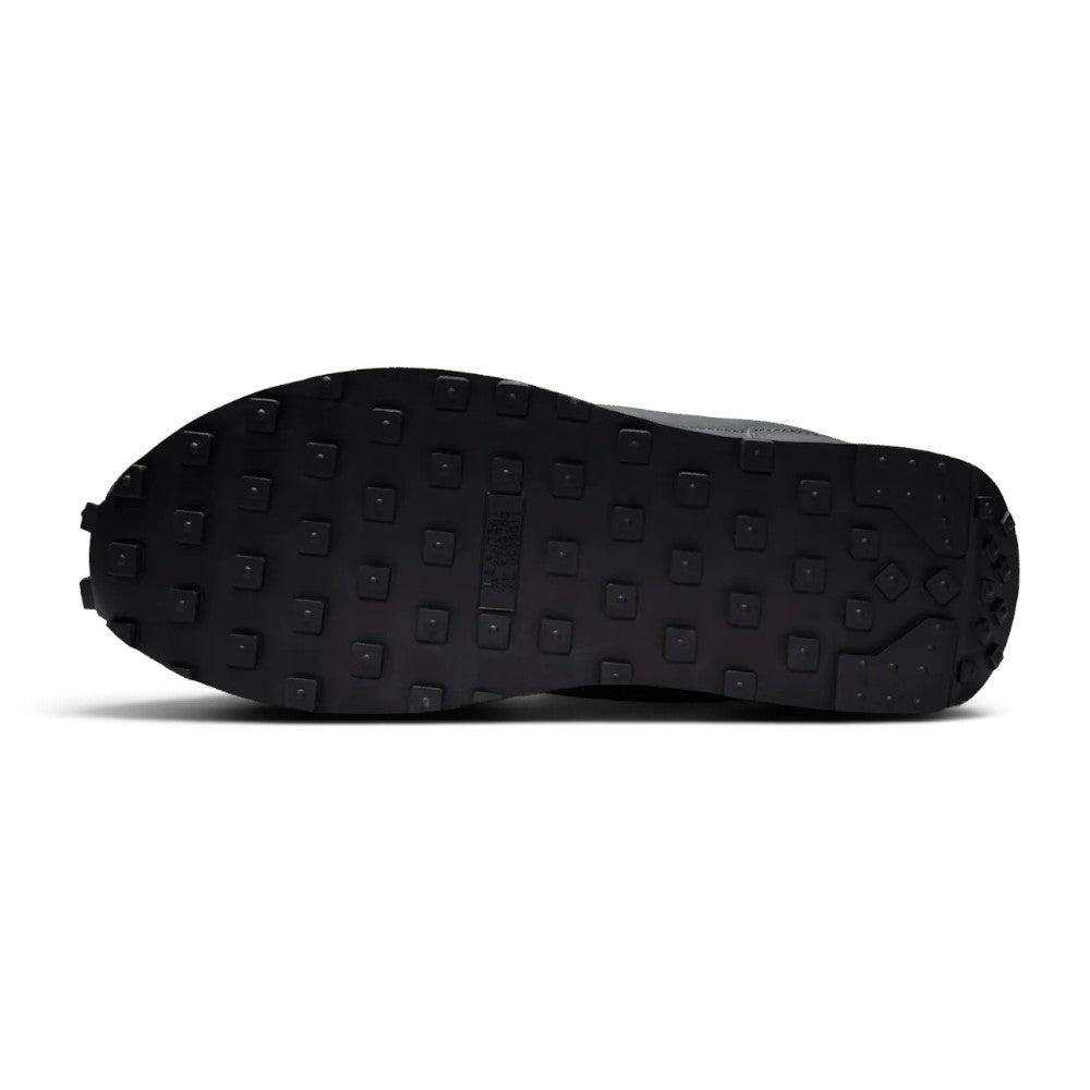 Focusing on the durable full-length black rubber outsole featuring iconic square-studded waffle traction lugs, toe bumper wrap, and classic heel crash curve, showcasing the grip matrix engineered for a successful tackle of city pavements, tarmac, and indoor flooring.