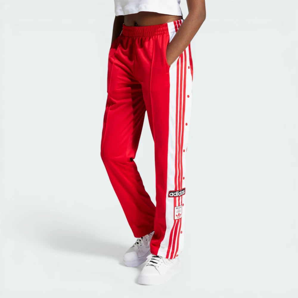 Side profile of the Better Scarlet Adibreak pants, highlighting the full-length white snap buttons and the contrast 3-Stripes. Main image