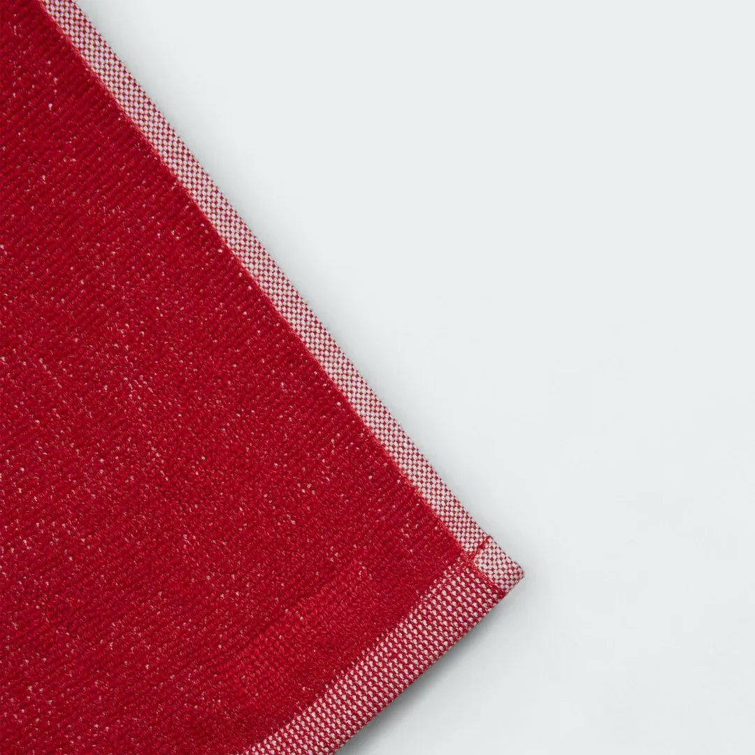 Detailed view of a corner of the Adidas Cotton Towel in red, highlighting the stitched edge