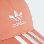 Close-up of an Adidas cap with logo and stripes on a light background