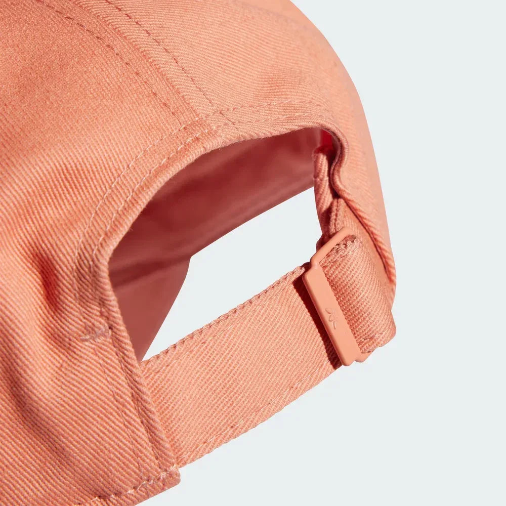 Close-up of a peach-colored cap on a light gray background