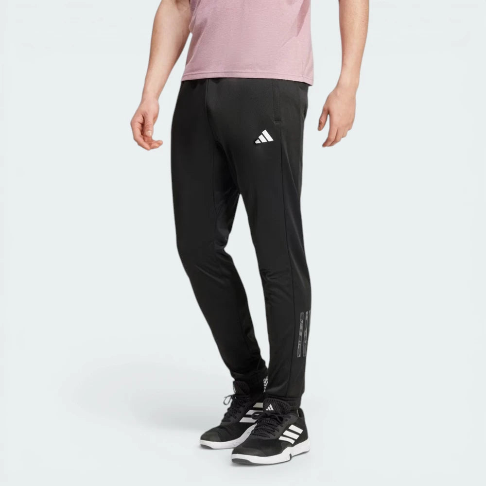 Side profile of the black Adidas training pants, highlighting the camouflage-print Three Stripes running down the leg.