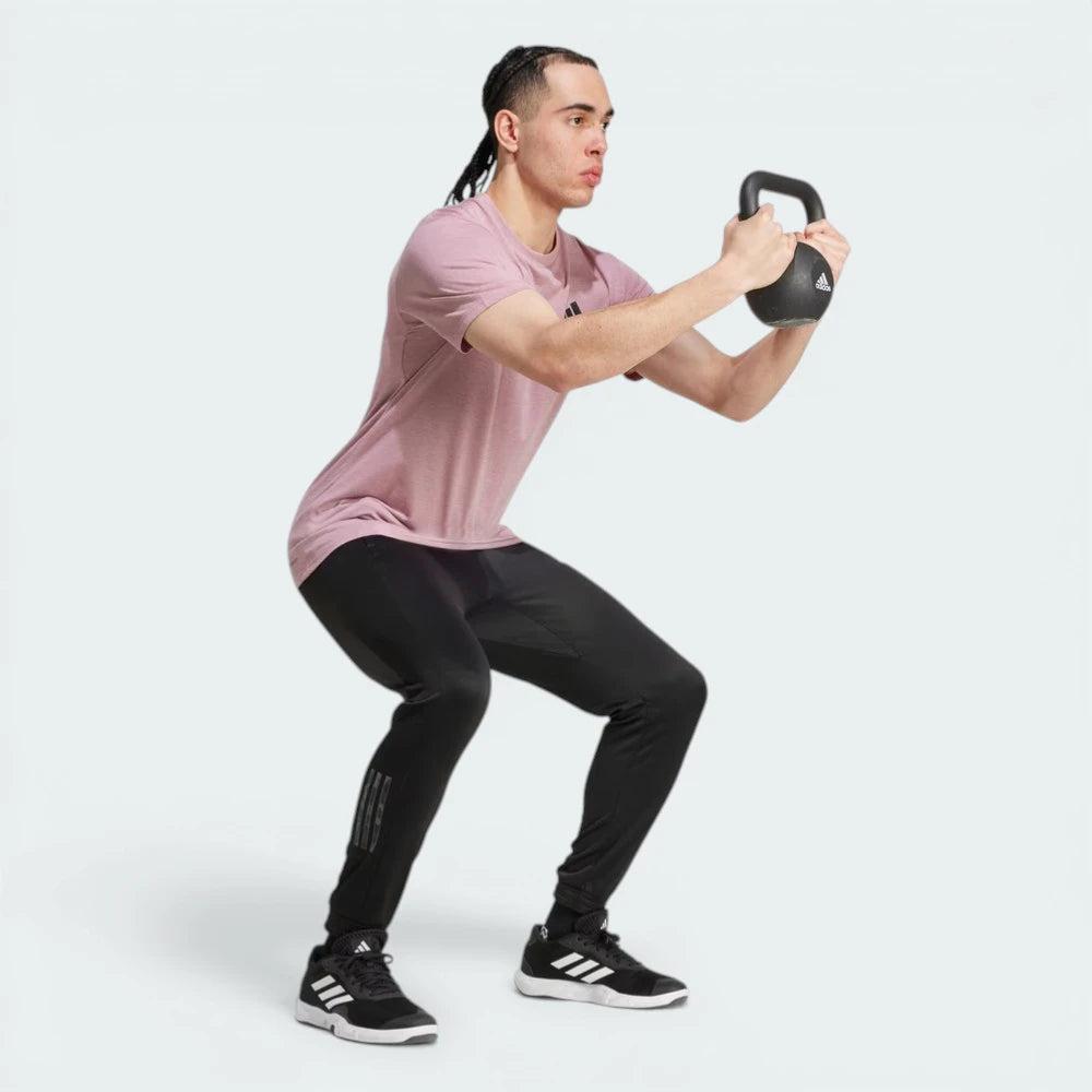 Person performing a kettlebell exercise on a white background