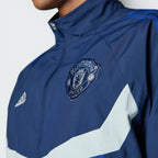 A close-up of the high-definition embroidery of the Manchester United crest and the white logo.