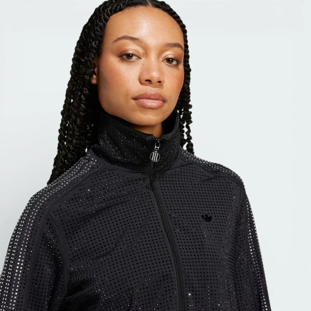 Close-up of the upper chest, focusing on the high-quality embroidery of the Trefoil logo and the sturdy metallic zipper pull.