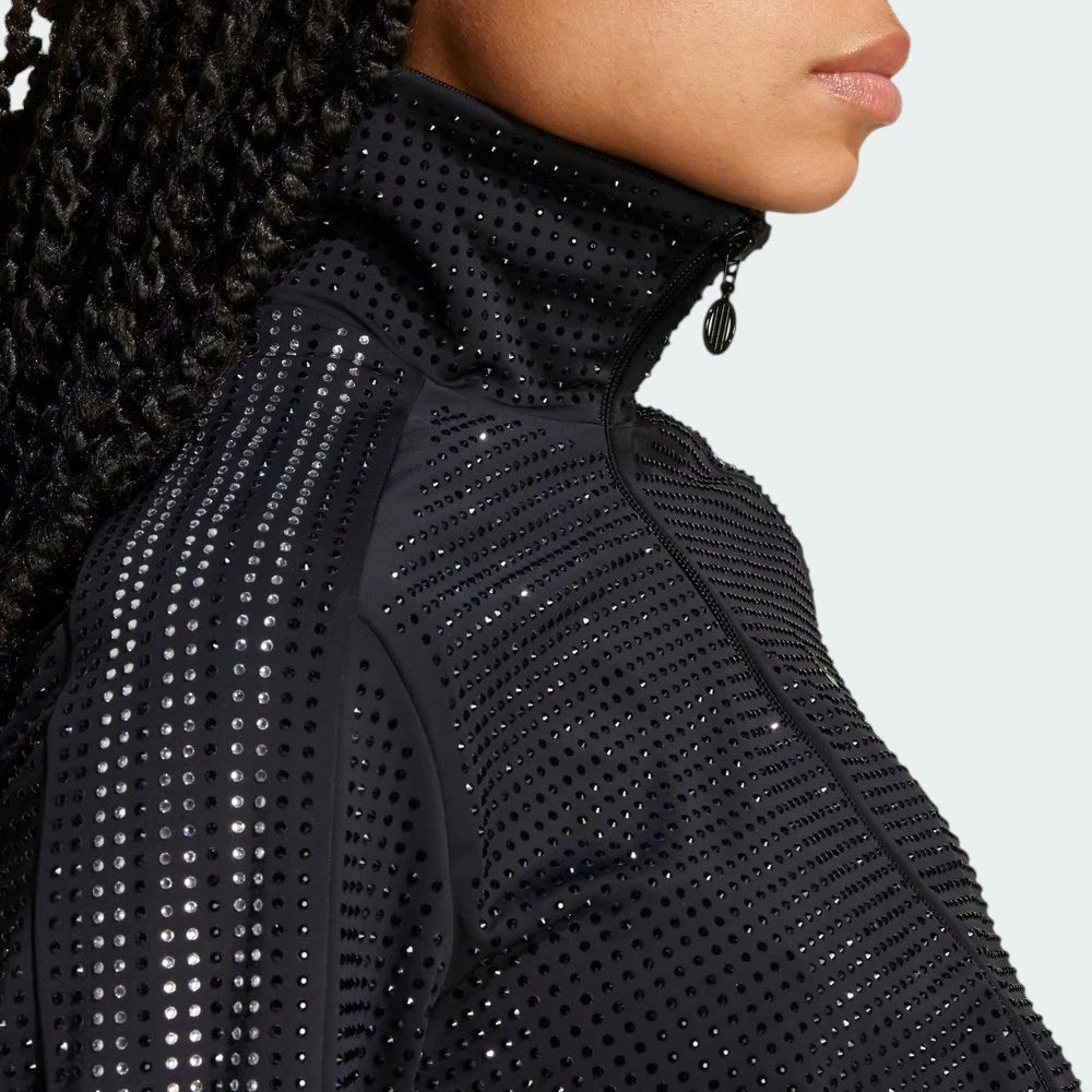 Side profile of the Preloved Ruby track jacket, showing the slim-fit silhouette and the iconic contrast 3-Stripes running down the sleeves.