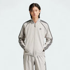 Front view of an Adidas Superstar Men's Bonded Track Top in Medium Grey (IW7318) on a model, showcasing its full design.