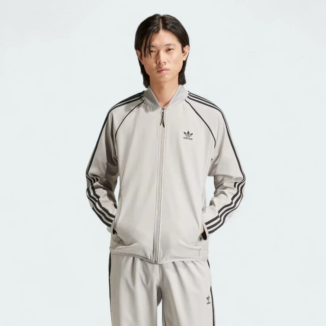Front view of an Adidas Superstar Men's Bonded Track Top in Medium Grey (IW7318) on a model, showcasing its full design.