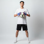 Person holding a soccer ball wearing gloves and Adidas sports gear on a white background