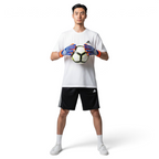 Person holding a soccer ball wearing gloves and Adidas sports gear on a white background