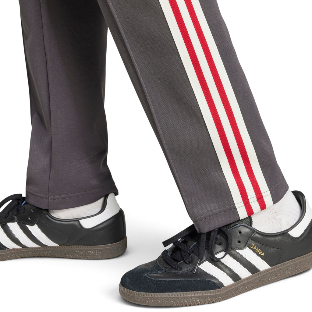 Trade Sports adidas Manchester United track pants in utility black with red and white side stripes worn with sneakers