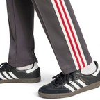 Trade Sports adidas Manchester United track pants in utility black with red and white side stripes worn with sneakers