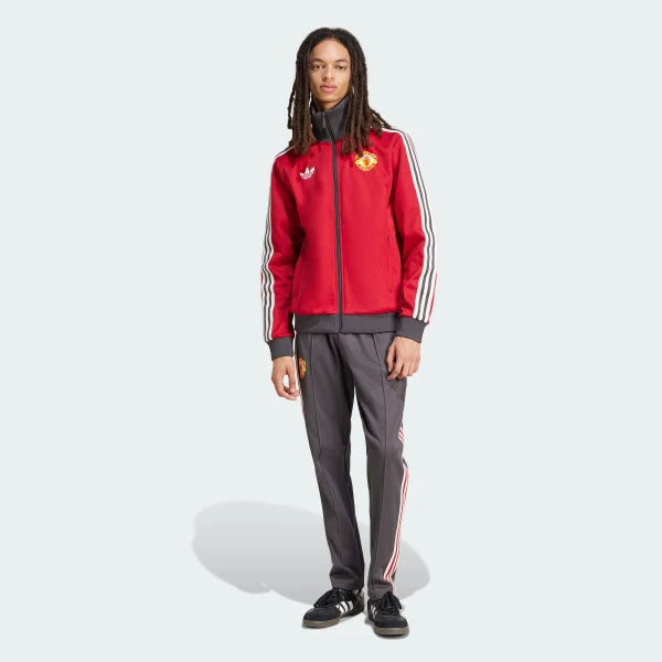 Person wearing a red Adidas tracksuit with white stripes on a white background