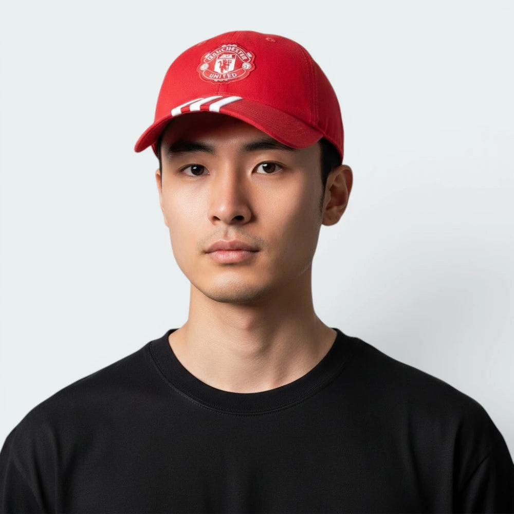 Highlights the high-velocity visual contrast of the iconic red, white, and yellow woven club crest sitting proud against the professional, deep scarlet depth of the Mufc Red crown paneling.