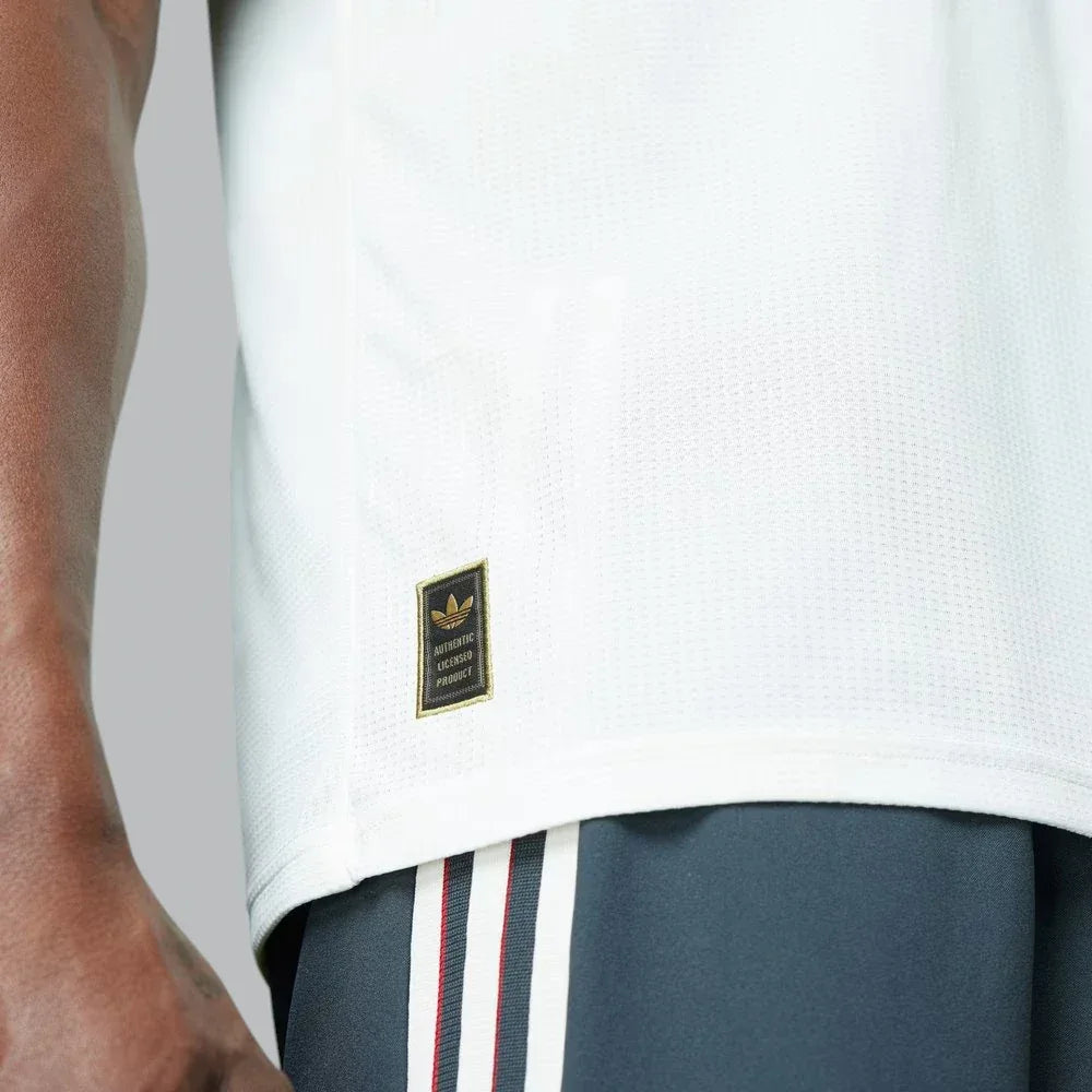 Detailed zoom on the authentic hem badge and the HEAT.RDY fabric structure, emphasizing the elite-tier manufacturing.