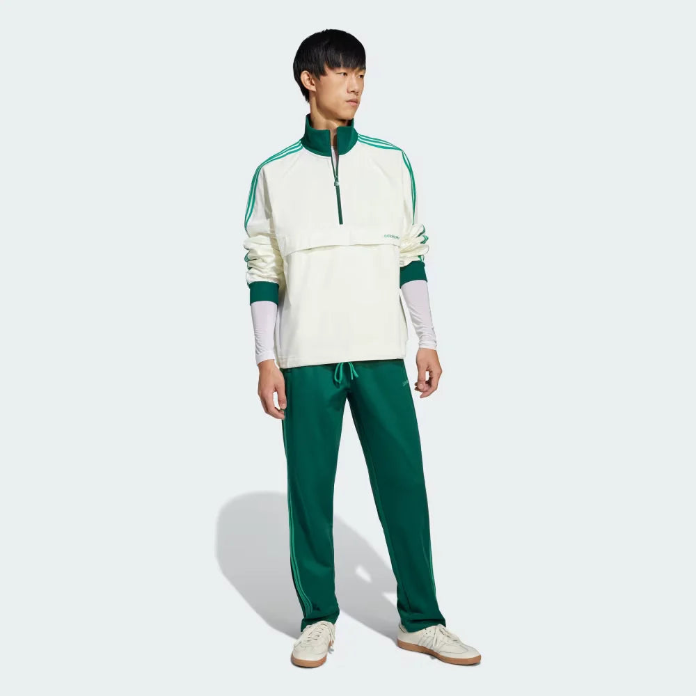Person wearing a white and green tracksuit on a light gray background