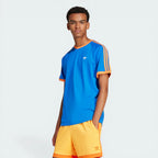 Model profile of the blue Adidas t-shirt, highlighting the slim fit and the textured ribbed cuffs on the sleeves.