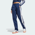 Side Profile Image: The Night Indigo Adibreak pants, highlighting the full-length white snap buttons and the contrast 3-Stripes against the dark navy base.