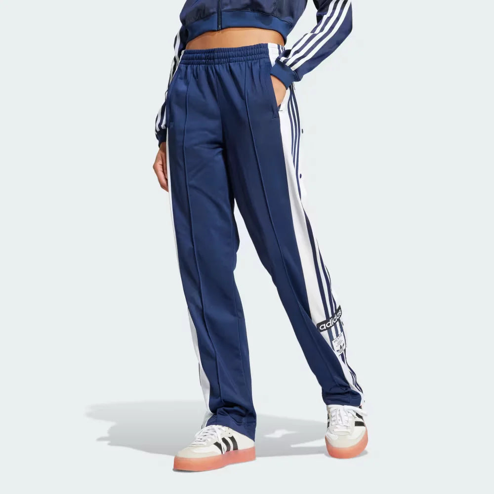 Side Profile Image: The Night Indigo Adibreak pants, highlighting the full-length white snap buttons and the contrast 3-Stripes against the dark navy base.
